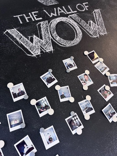 Als „Wall of Wow" beschriftete Wand mit einer Collage aus Porträtfotos.